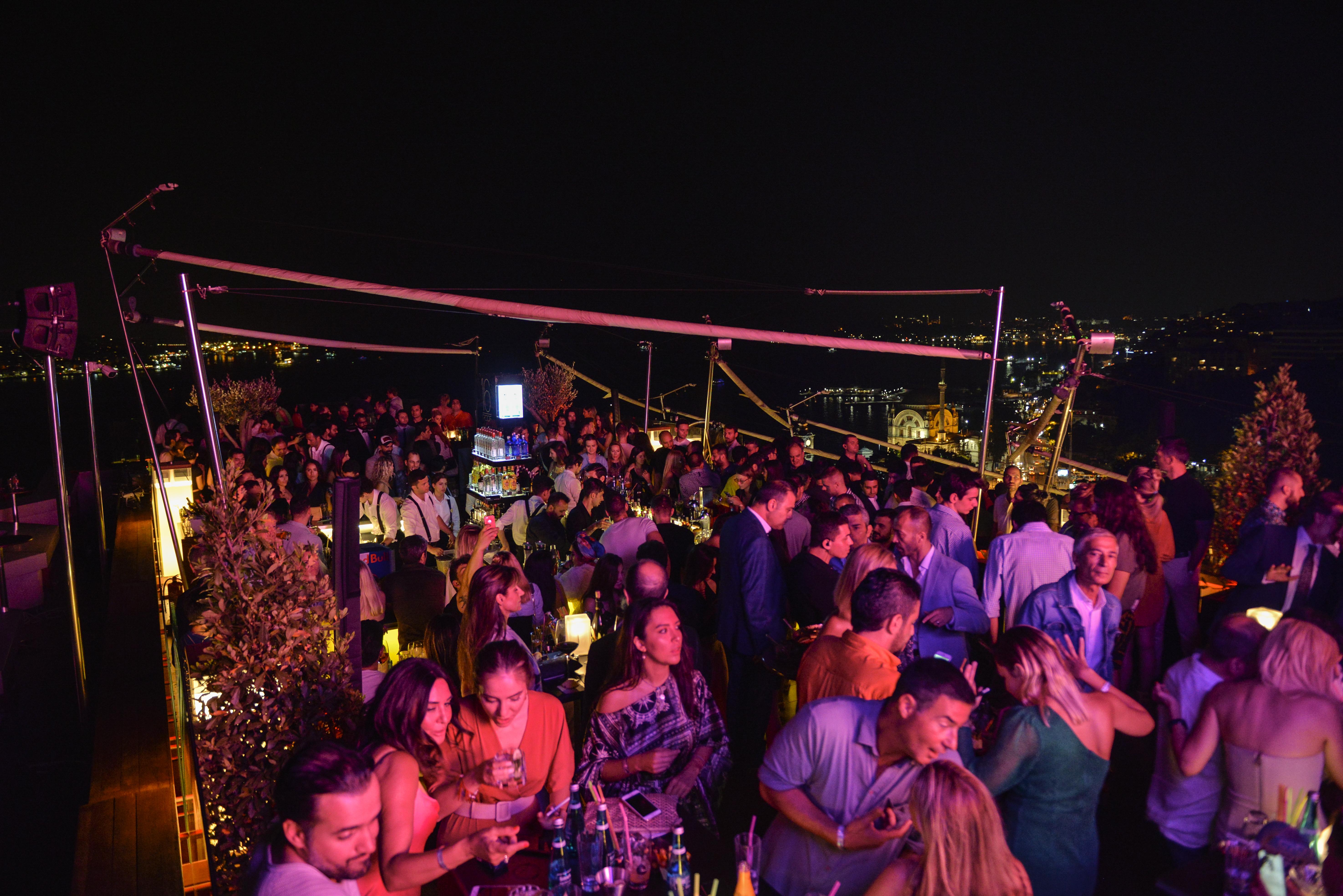 Swissotel The Bosphorus Istanbul Luaran gambar The photo depicts a vibrant rooftop venue at night, filled with a large crowd of people enjoying themselves. The atmosphere appears lively, with many individuals socializing, dancing, and holding drinks. The setting is adorned with soft lighting and 