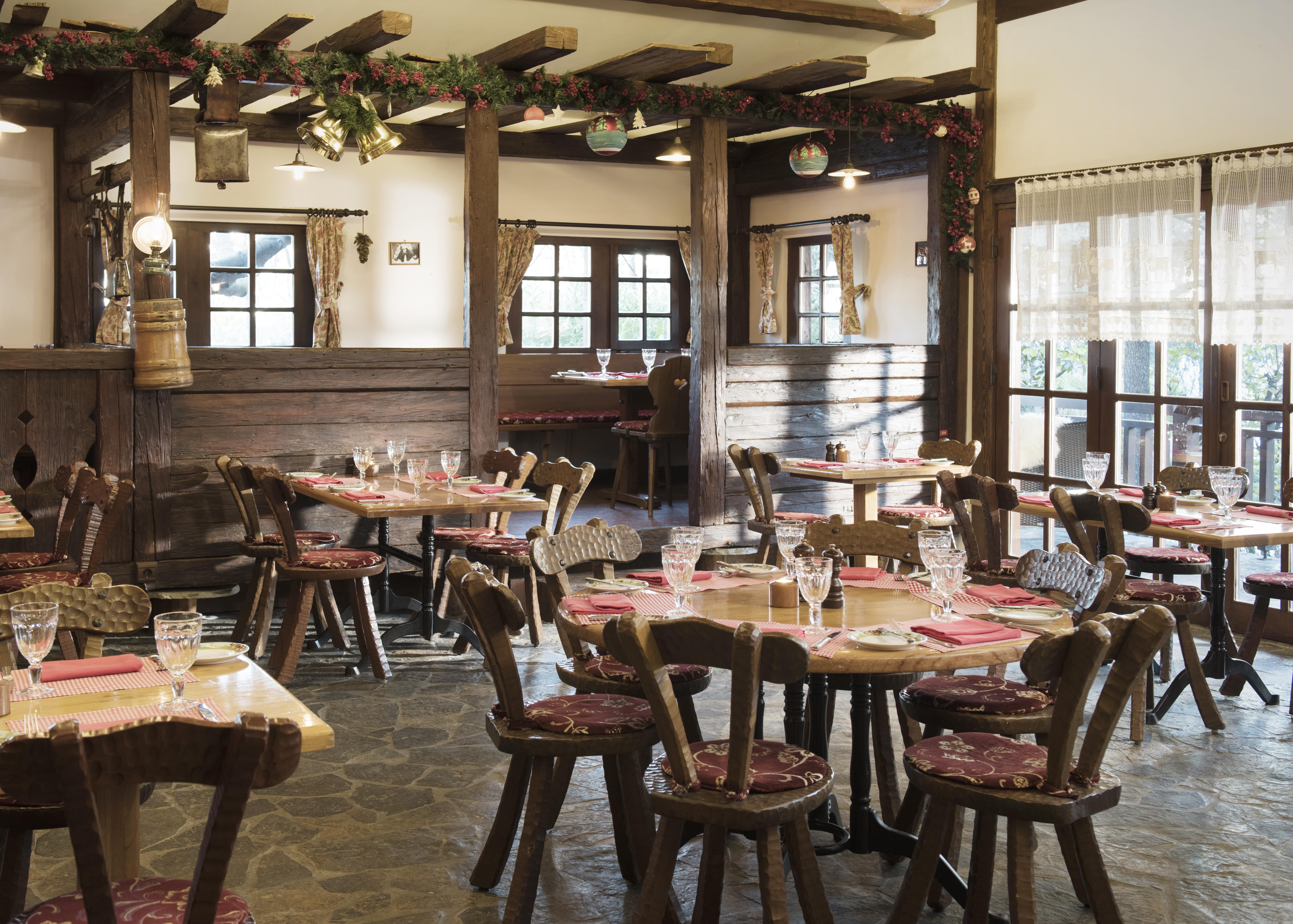 Swissotel The Bosphorus Istanbul Luaran gambar The photo shows the interior of a cozy restaurant. It features wooden tables and chairs arranged around the space, with each table set with glasses and menus. The decor includes wooden beams and warm lighting, creating an inviting atmosphere. Some ta