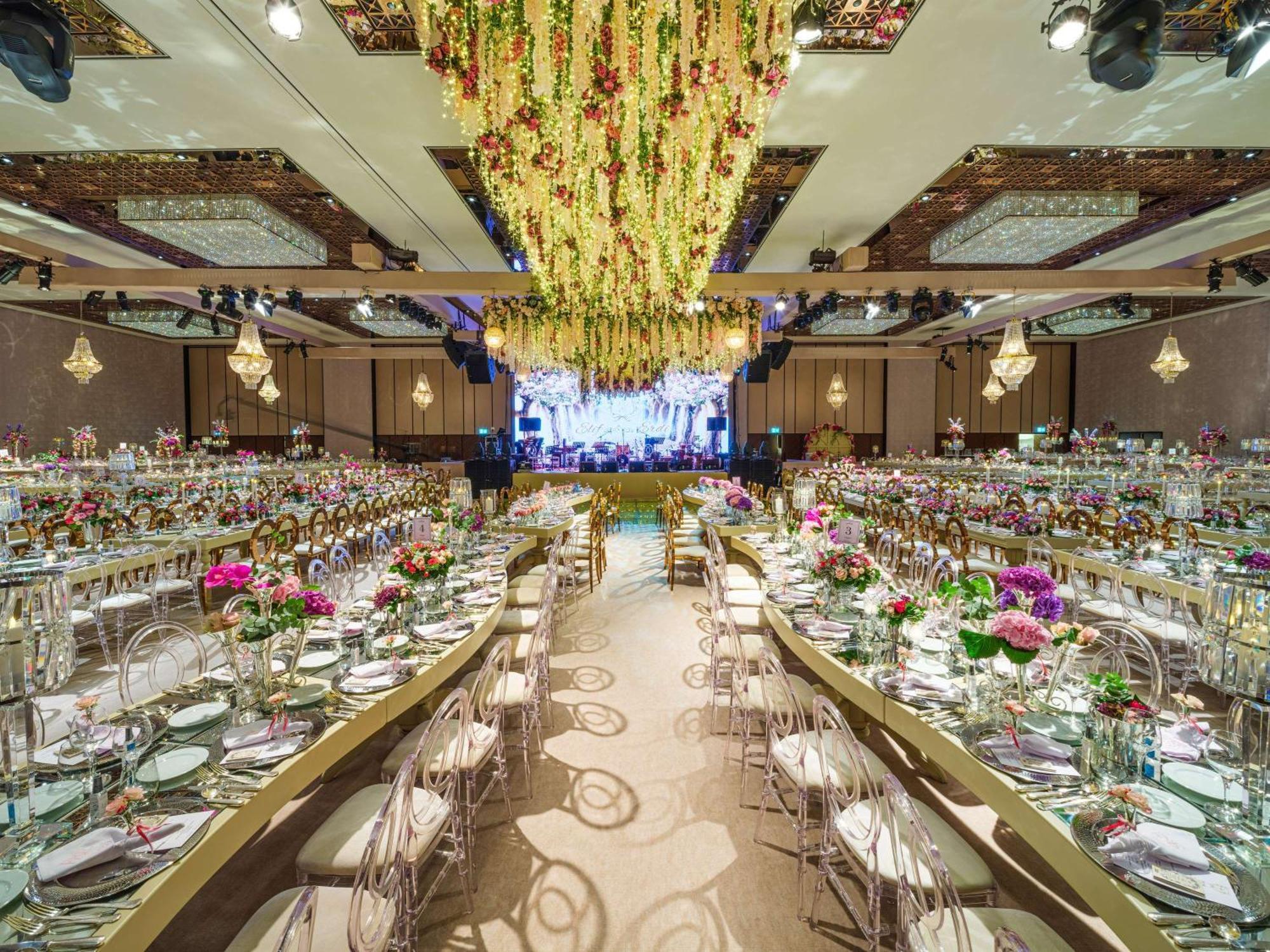 Swissotel The Bosphorus Istanbul Luaran gambar The photo shows an elegantly decorated banquet hall set up for an event. There are long tables arranged in a U-shape, adorned with floral centerpieces and neatly set dinnerware. The decor features vibrant flowers in various colors. Above the tables, 