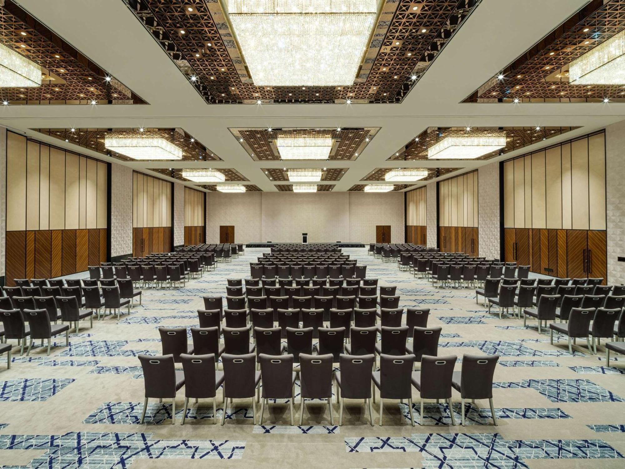 Swissotel The Bosphorus Istanbul Luaran gambar The photo shows a large conference or banquet hall. It features numerous rows of chairs arranged in a neat, organized manner. The room has a modern aesthetic with high ceilings, decorative lighting fixtures, and a stylish carpet design. The walls are